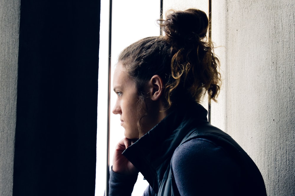 woman in black shirt looking at the window