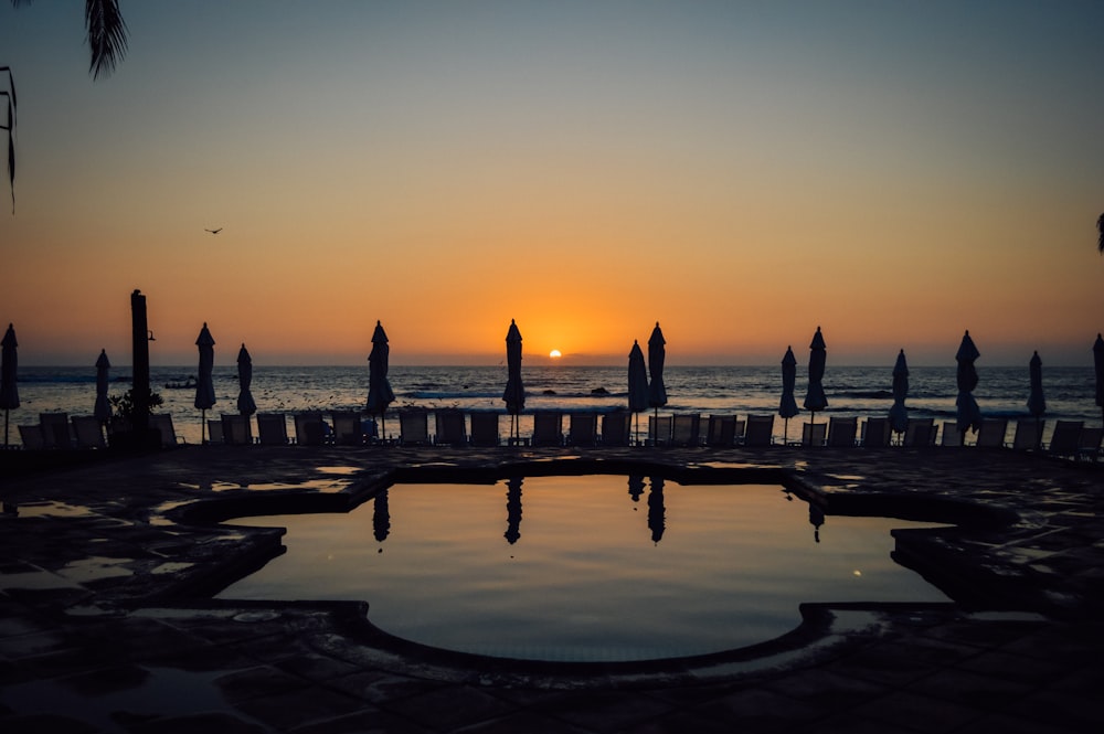 Gente caminando por la playa durante la puesta de sol