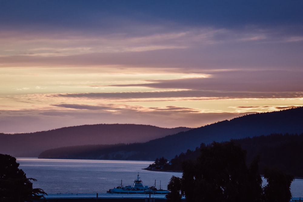 Bateau blanc sur la mer au coucher du soleil