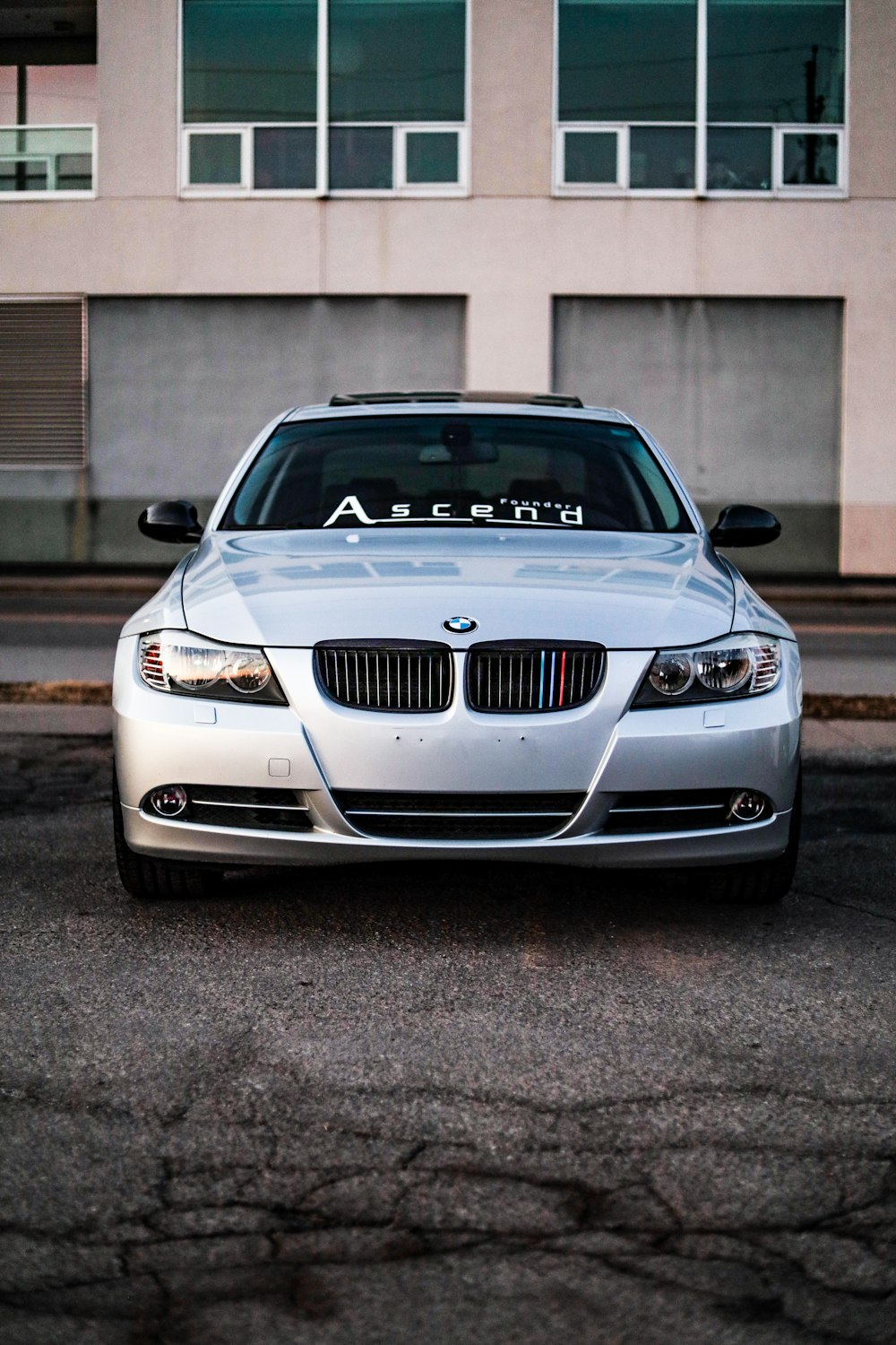 日中に歩道に駐車された白いBMW M3