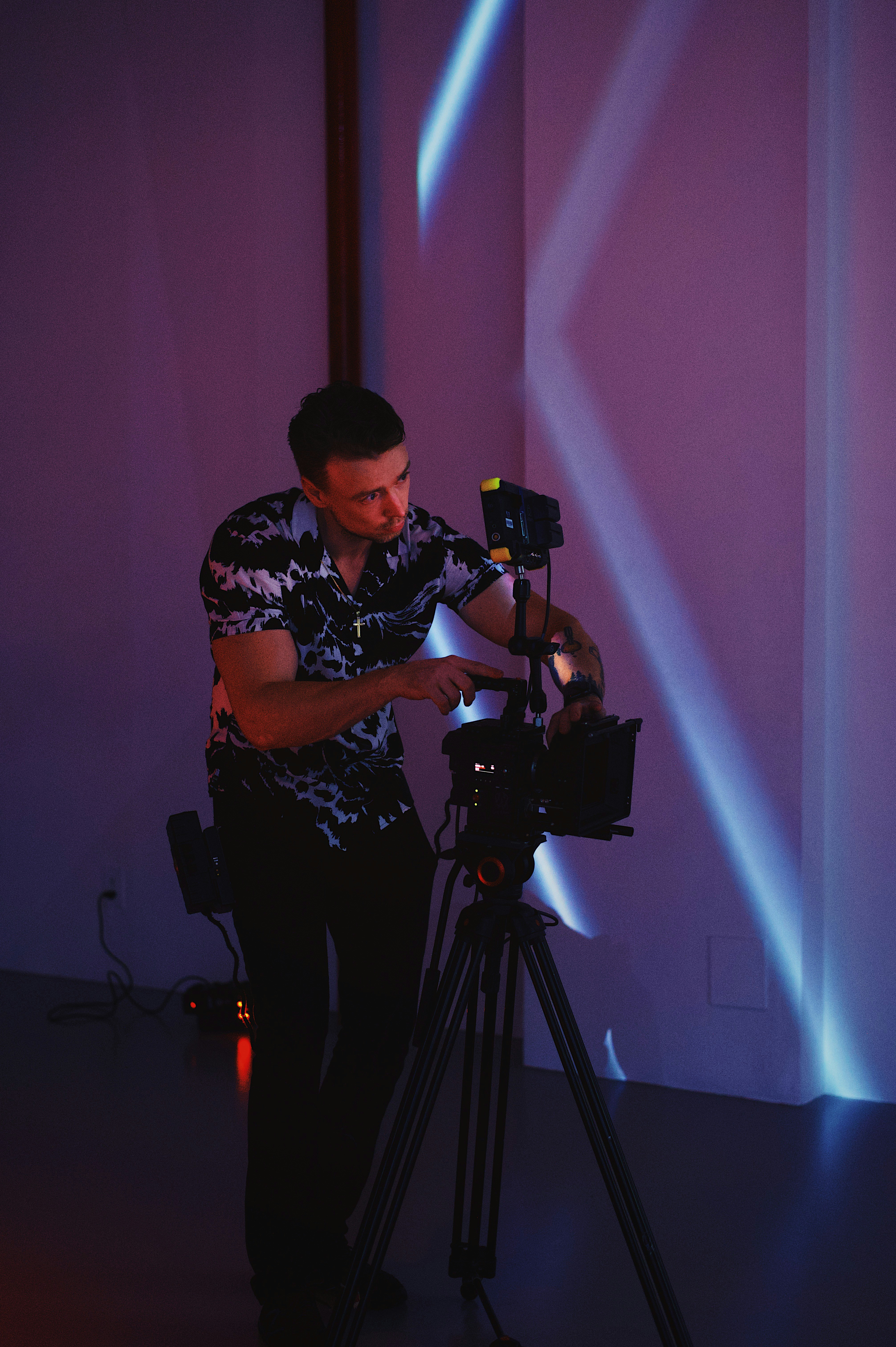 man in black and white floral shirt holding black dslr camera
