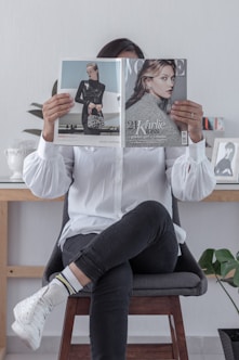 woman in white long sleeve shirt and black pants sitting on chair