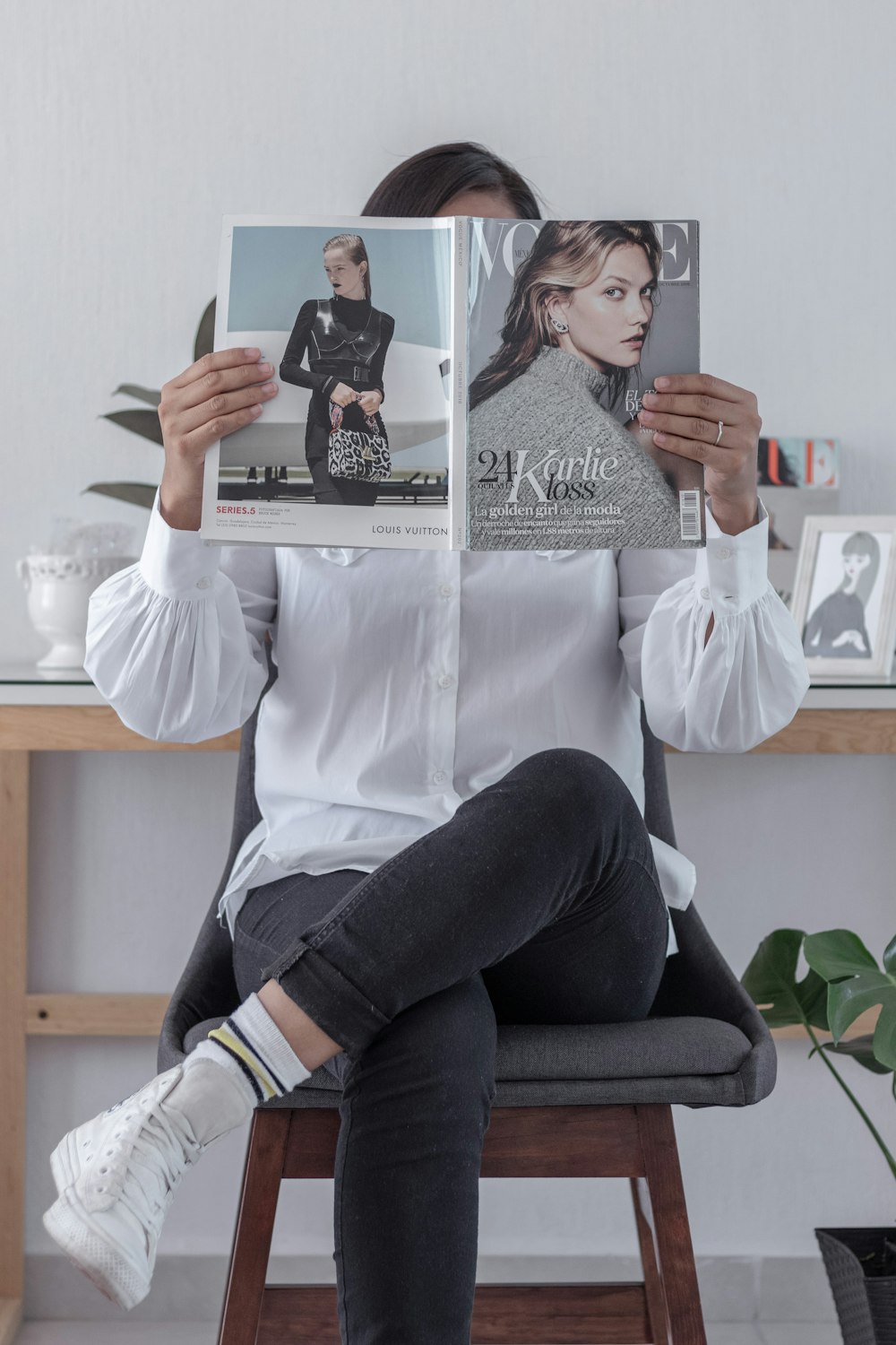 woman in white long sleeve shirt and black pants sitting on chair