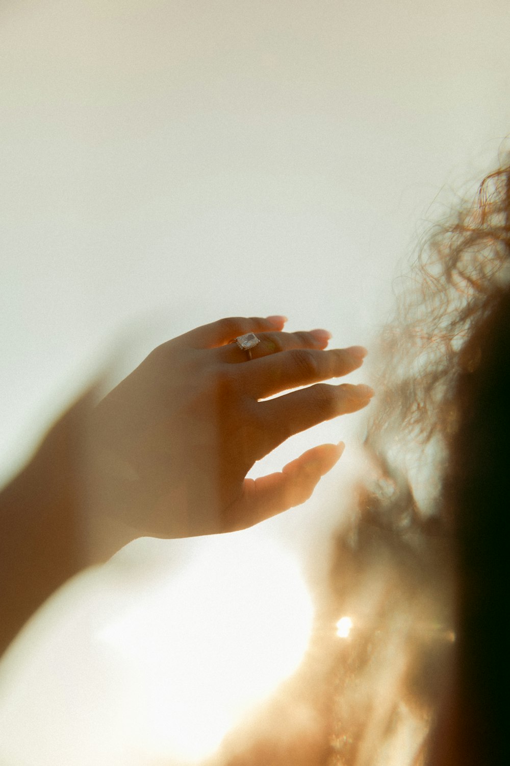 person holding her hair near white wall