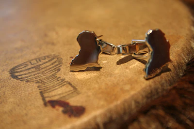 Elegant cufflinks shining under soft lighting on a dark fabric background.