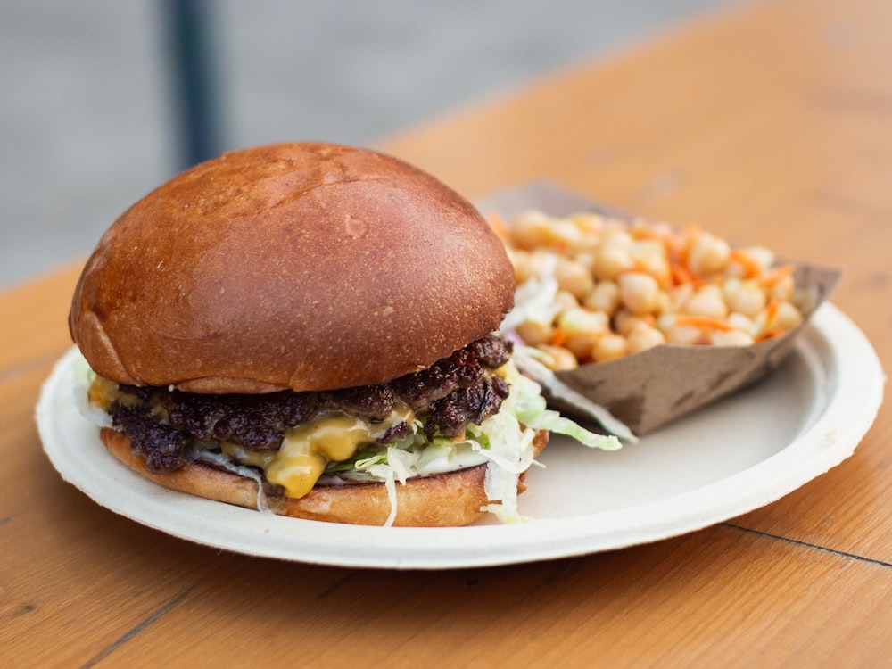 burger with lettuce and fries on white ceramic plate