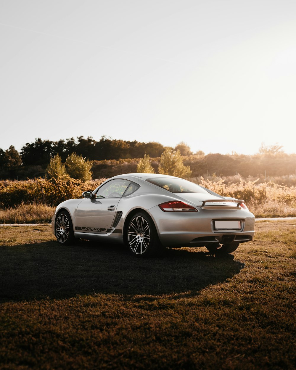 white porsche 911 on brown field during daytime