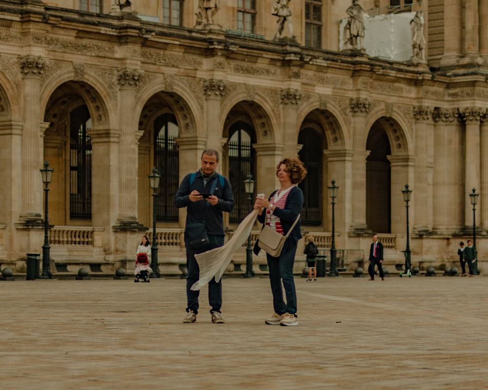 man in black suit holding woman in white dress walking on street during daytime