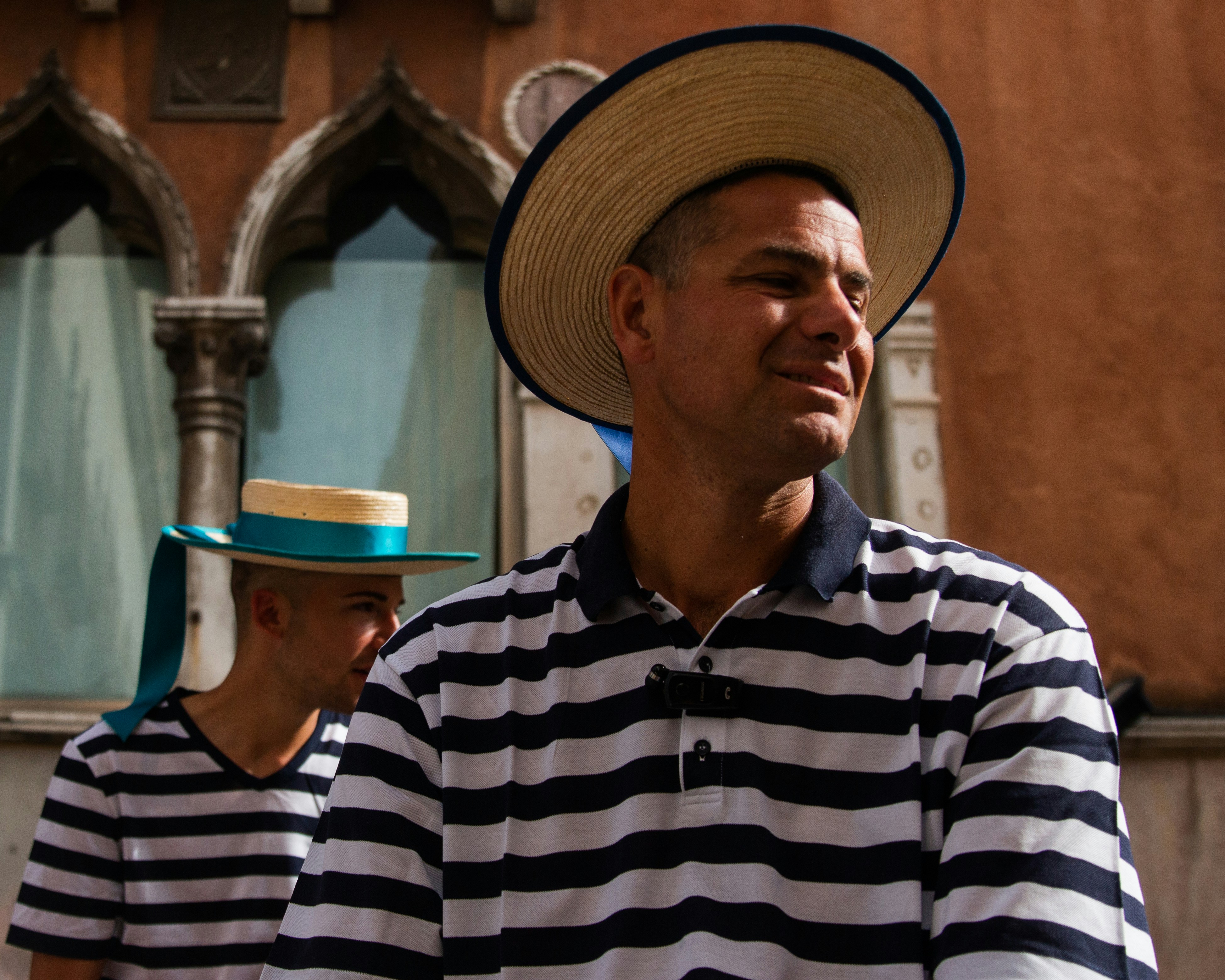 man in black and white striped polo shirt wearing brown hat