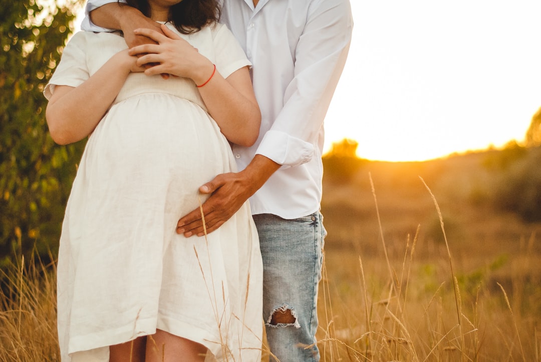 man in white dress shirt and blue denim jeans kissing woman in white dress shirt