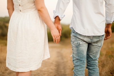 Lifestyle shot of a couple walking hand in hand along a serene path.