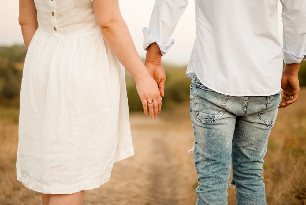 man and woman holding hands while walking