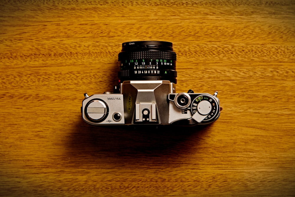 silver and black camera on brown wooden table