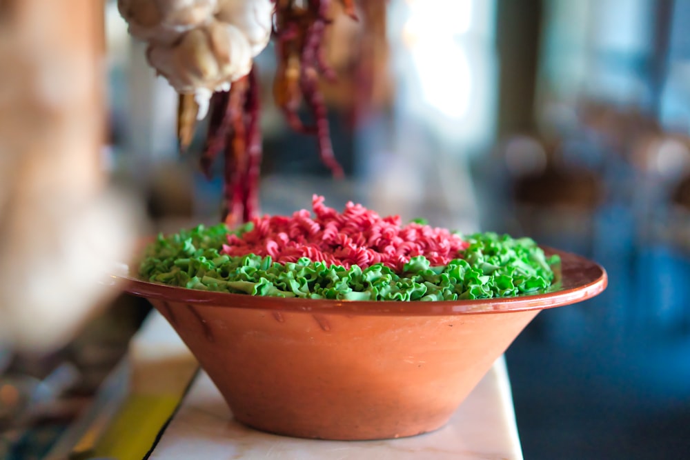 white and red flower in brown clay pot