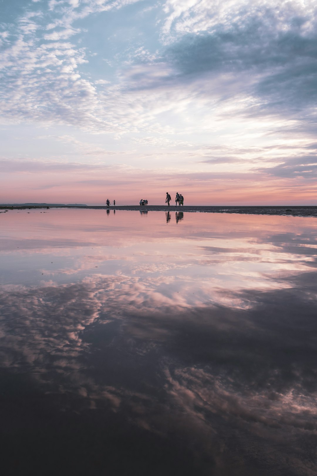 silhouette of 2 people standing on beach during sunset