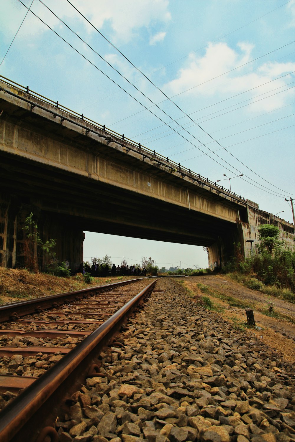 brown metal train rail under white sky during daytime
