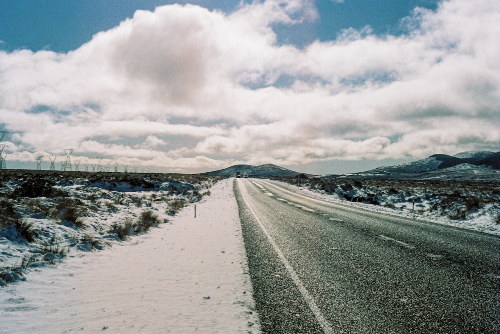 日中の曇り空の下、雪に覆われた道路