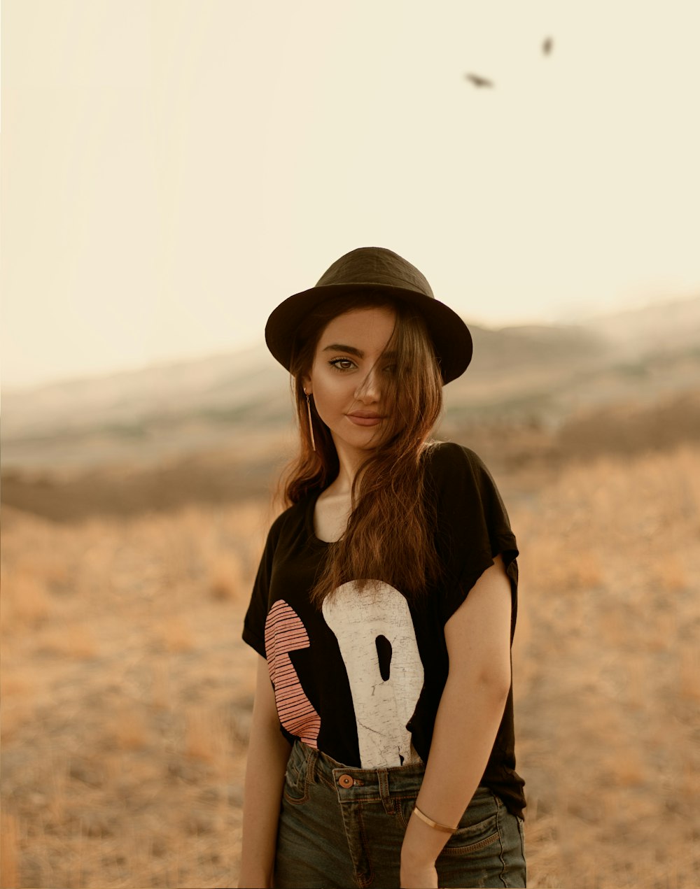 woman in black and white stripe shirt and brown fedora hat