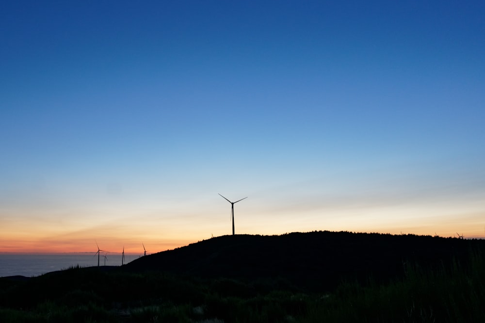 turbine eoliche sul campo di erba verde durante il tramonto