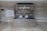 A welcome area with a large sign featuring the logo 'syngenta' and a message for business partners and country leadership team is displayed on a wall. There is a seating plan on a wooden easel to the left, and a table with wrapped items in front of the sign.