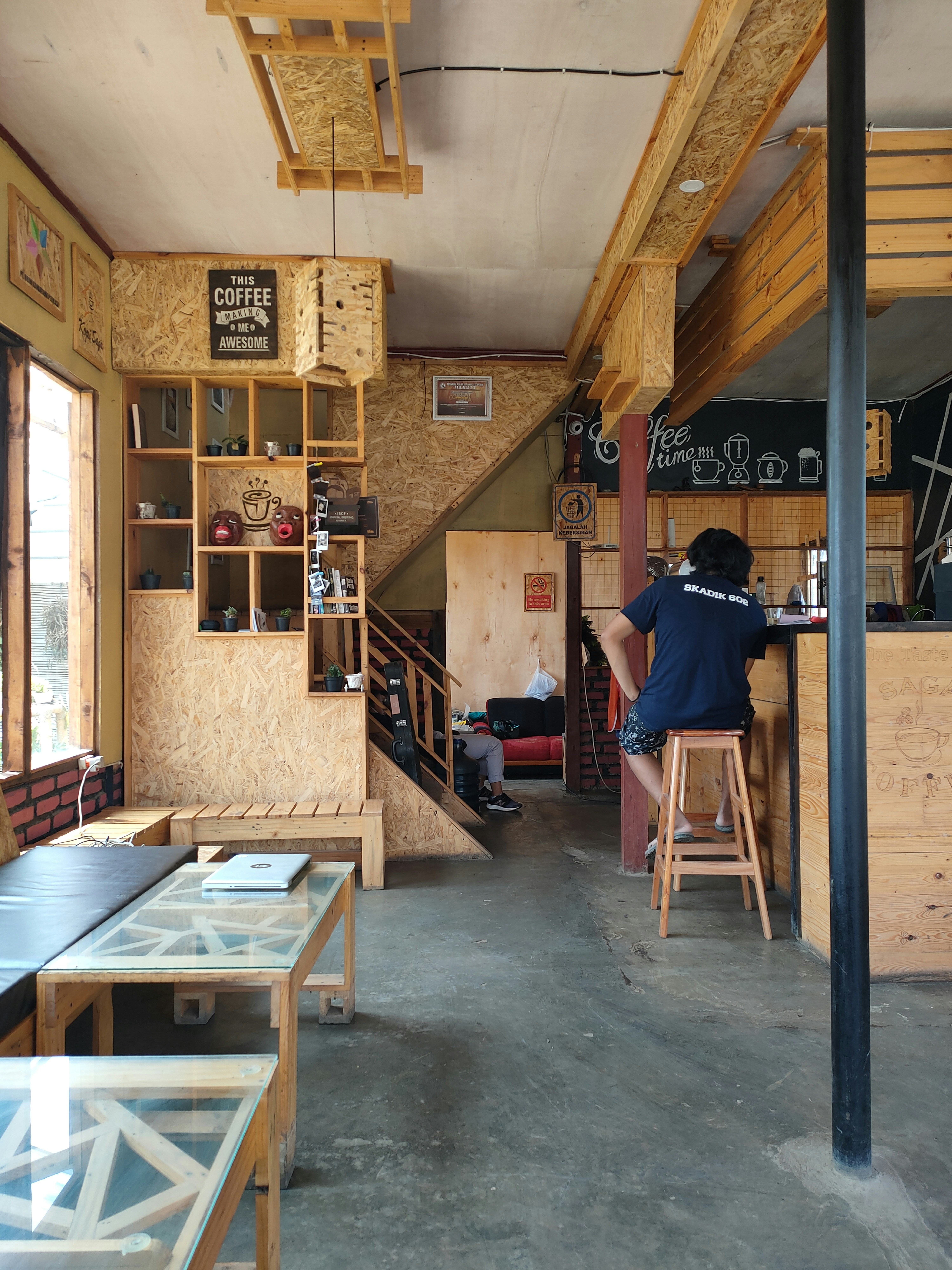 Mann in schwarzer Jacke sitzt auf braunem Holzstuhl