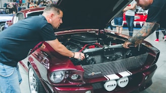 man in black t-shirt sitting on red car
