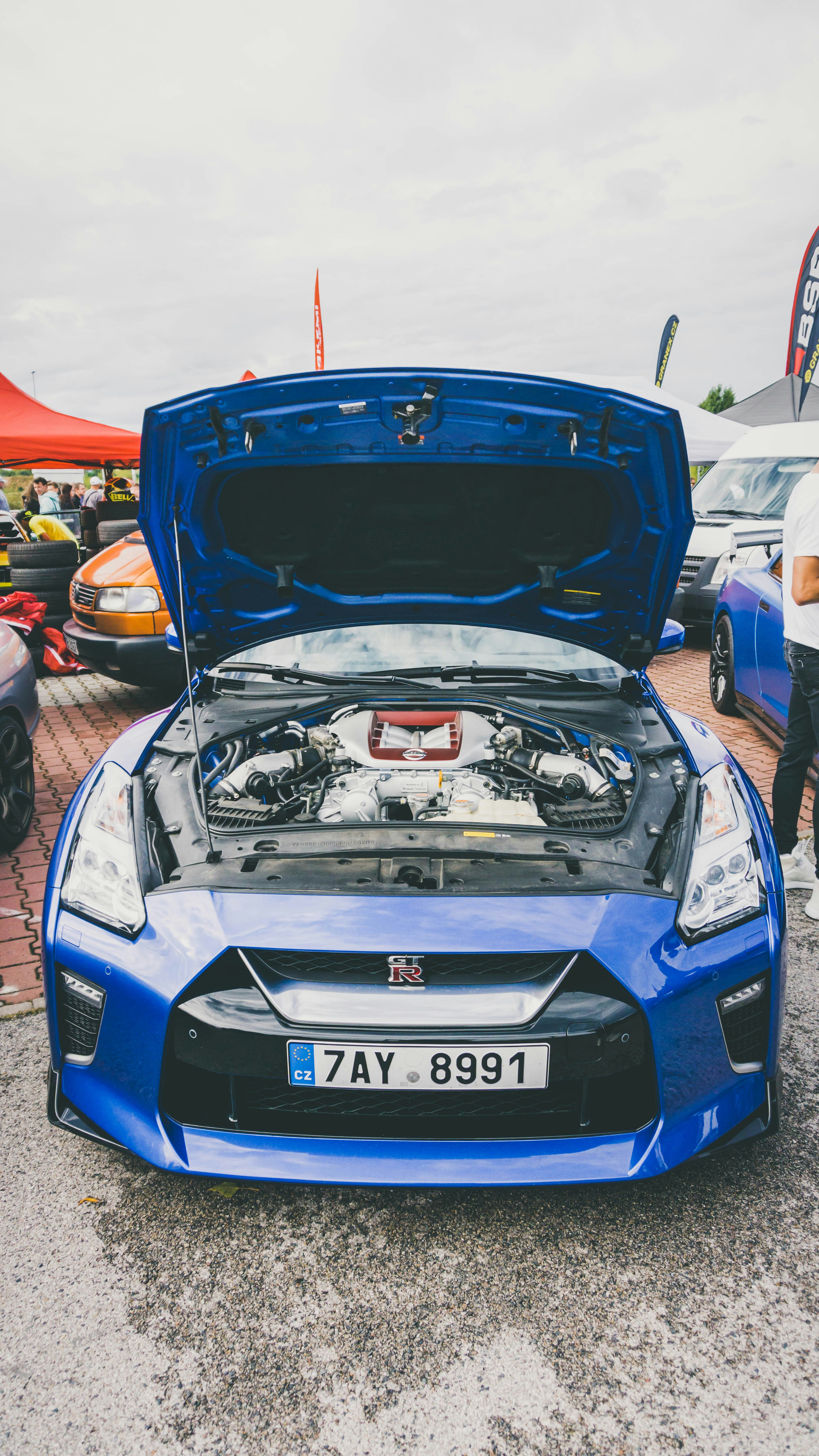 Blue Nissan GT-R with carbon fiber hood and racing wheels at car meet