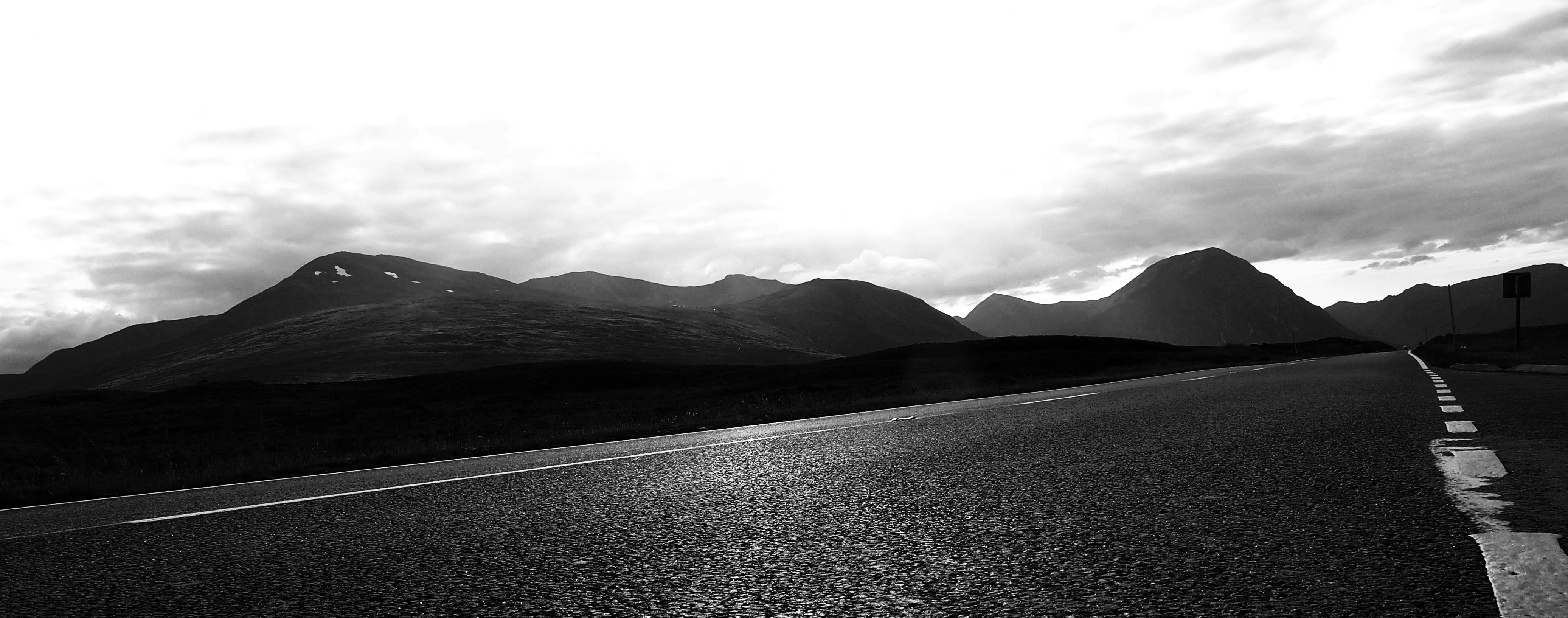grayscale photo of mountains and clouds