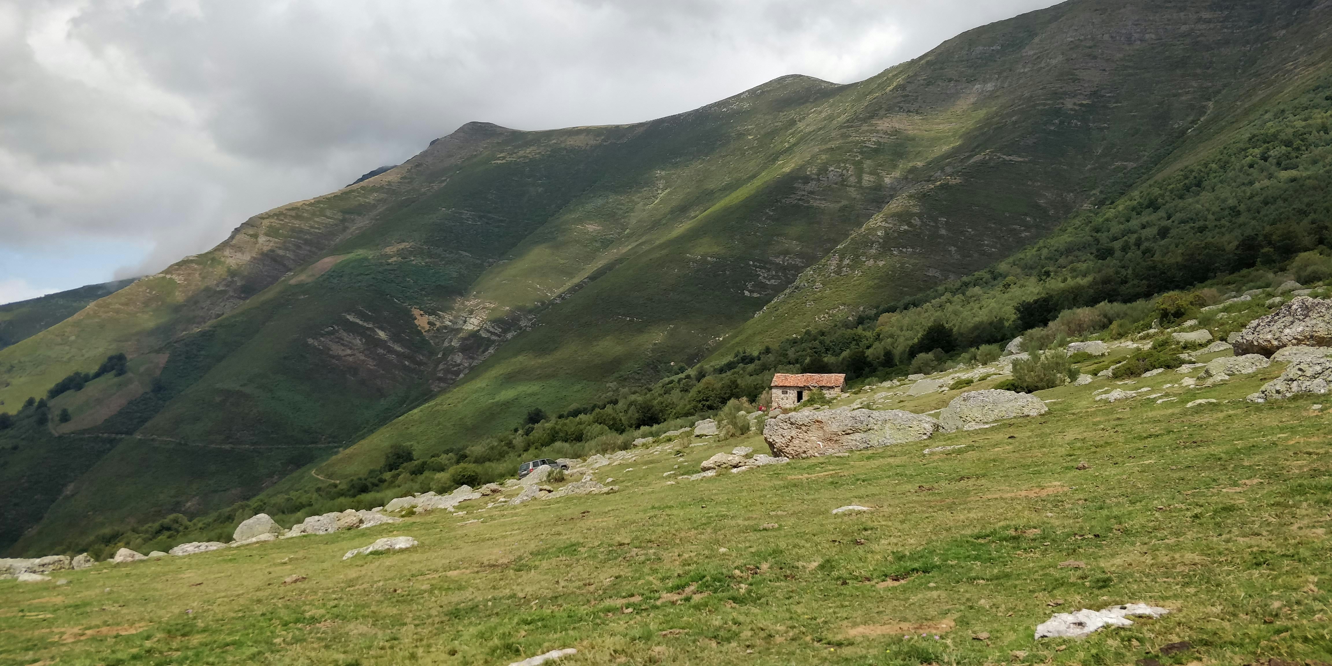 casa marrom no campo de grama verde perto da montanha durante o dia