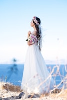 woman in white wedding dress standing on brown grass field during daytime