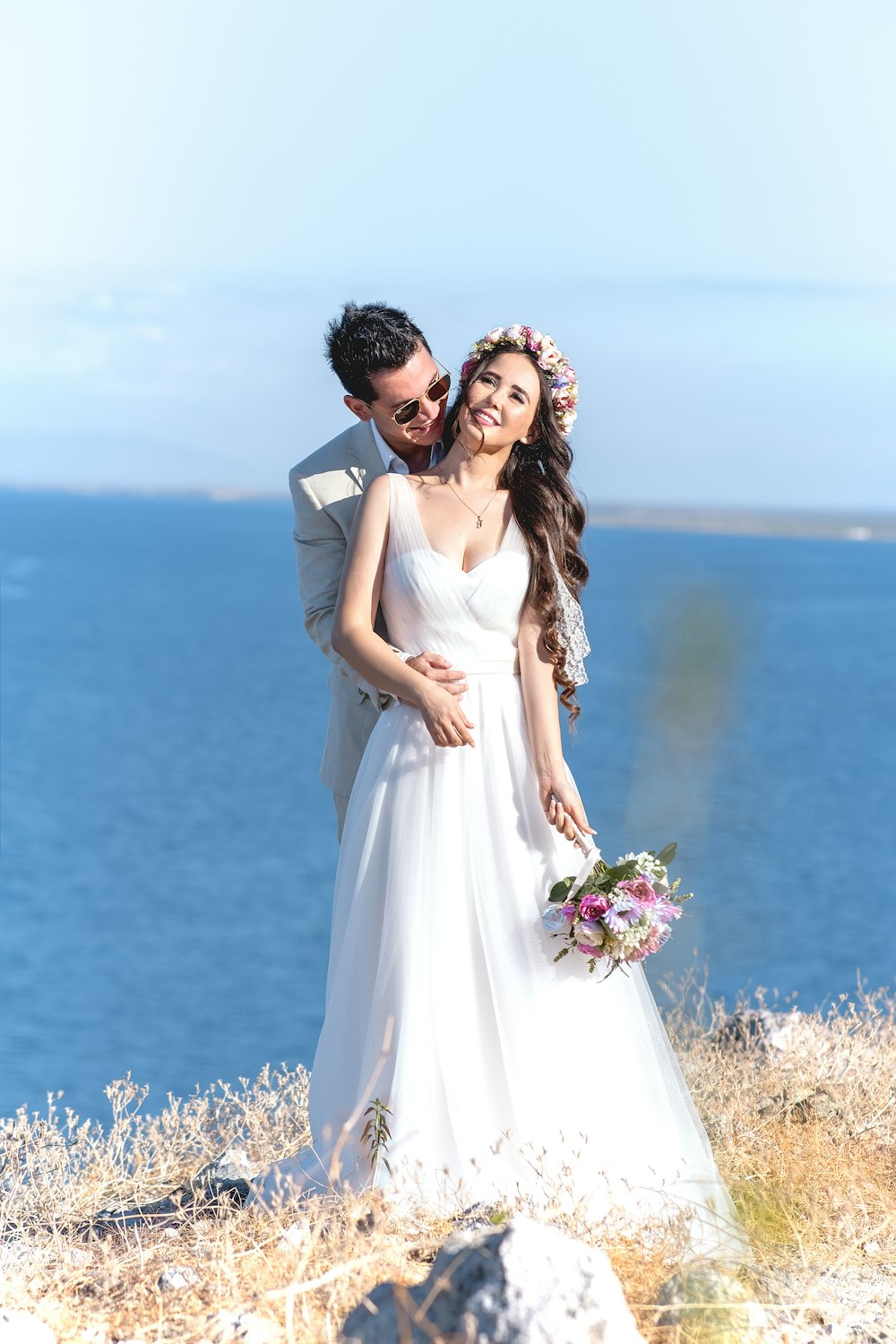 mujer en vestido de novia blanco de pie junto al hombre en traje gris