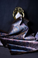 gold crown on blue and gray textile
