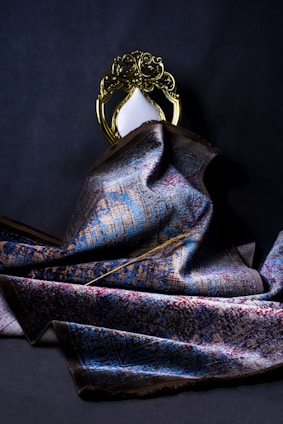 gold crown on blue and gray textile