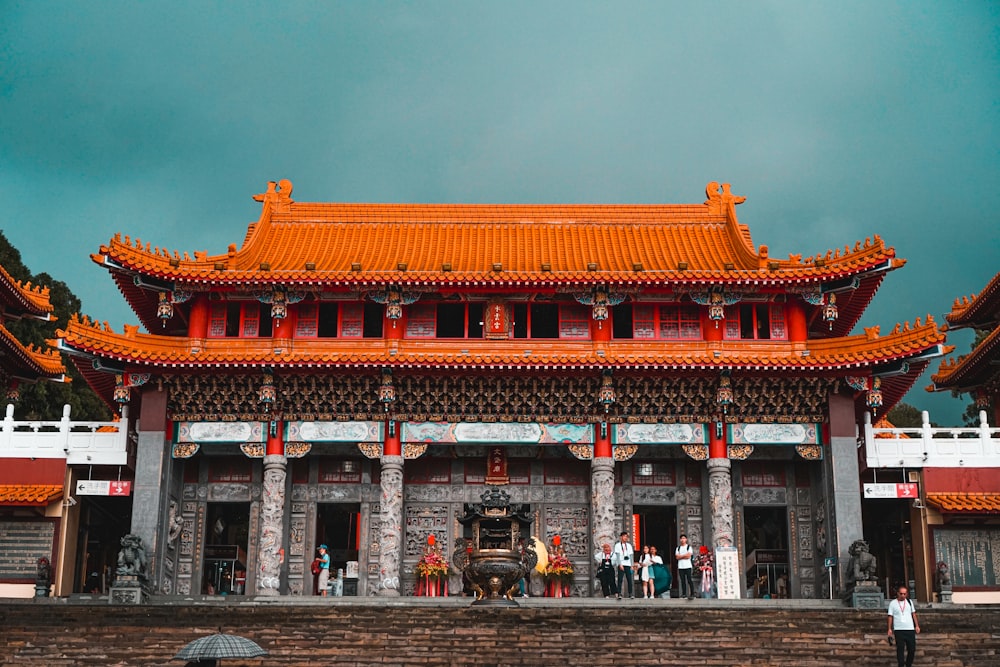 people walking on orange and white temple during daytime