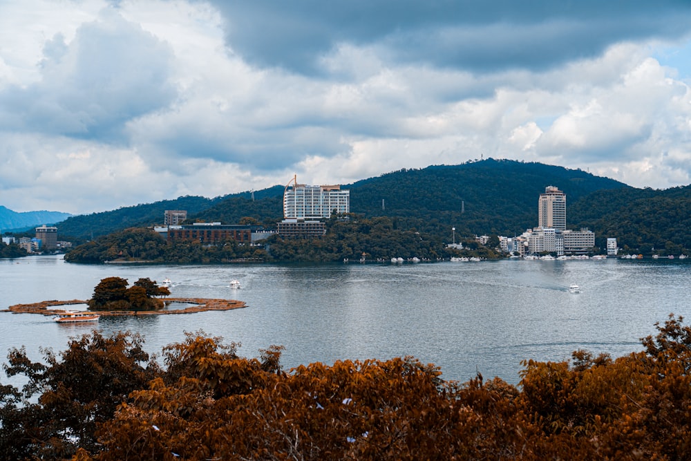 white and gray concrete building near body of water under cloudy sky during daytime