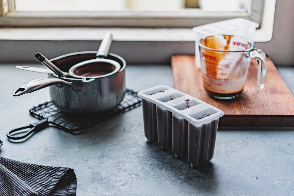 white and orange plastic cup beside black plastic container