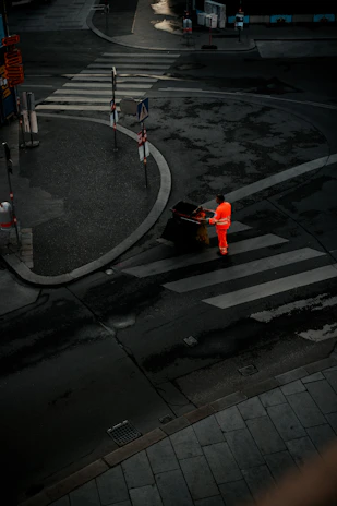 Early morning scene of a Binshufflers worker wheeling bins along a suburban street.