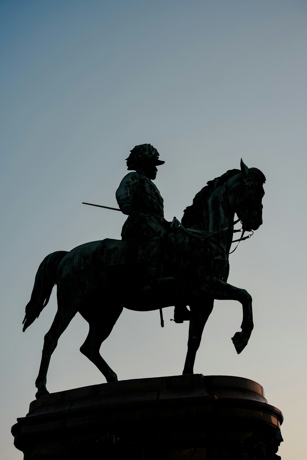 man riding horse statue under blue sky during daytime