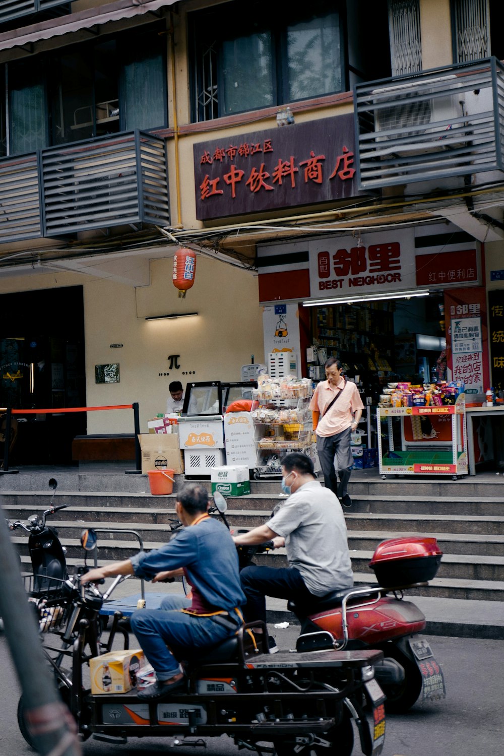 man in gray shirt and blue denim jeans sitting on red motorcycle during daytime