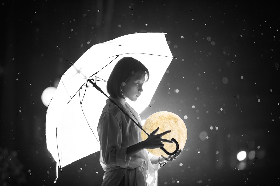 girl in white coat holding umbrella