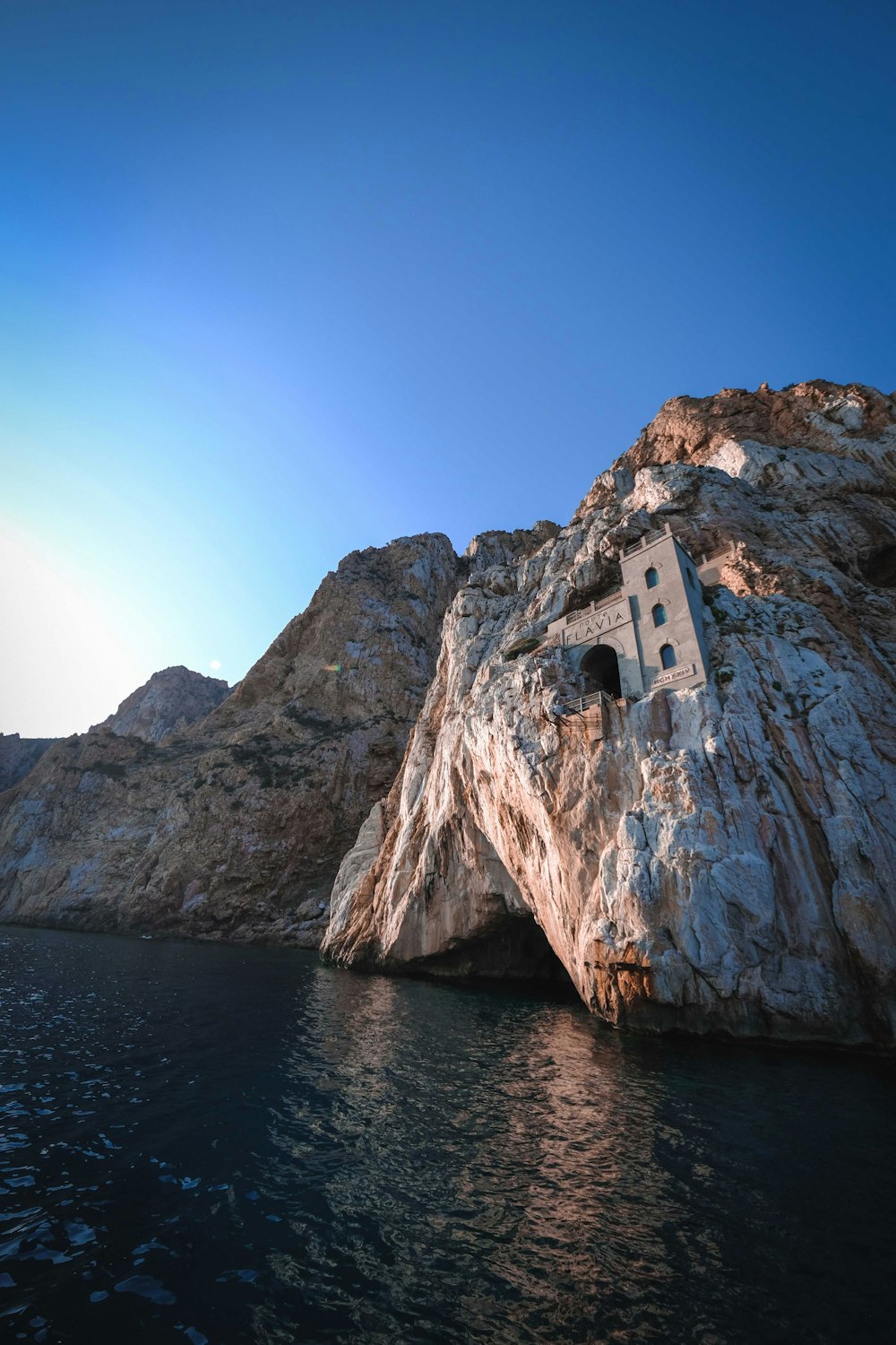 brown rock formation on body of water during daytime