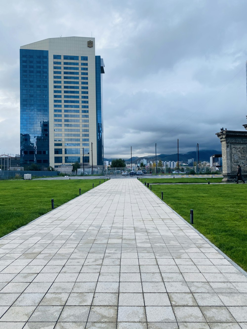 green grass field near city buildings during daytime