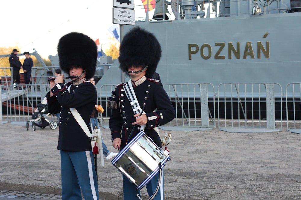 uomo in uniforme nera e rossa che suona il tamburo