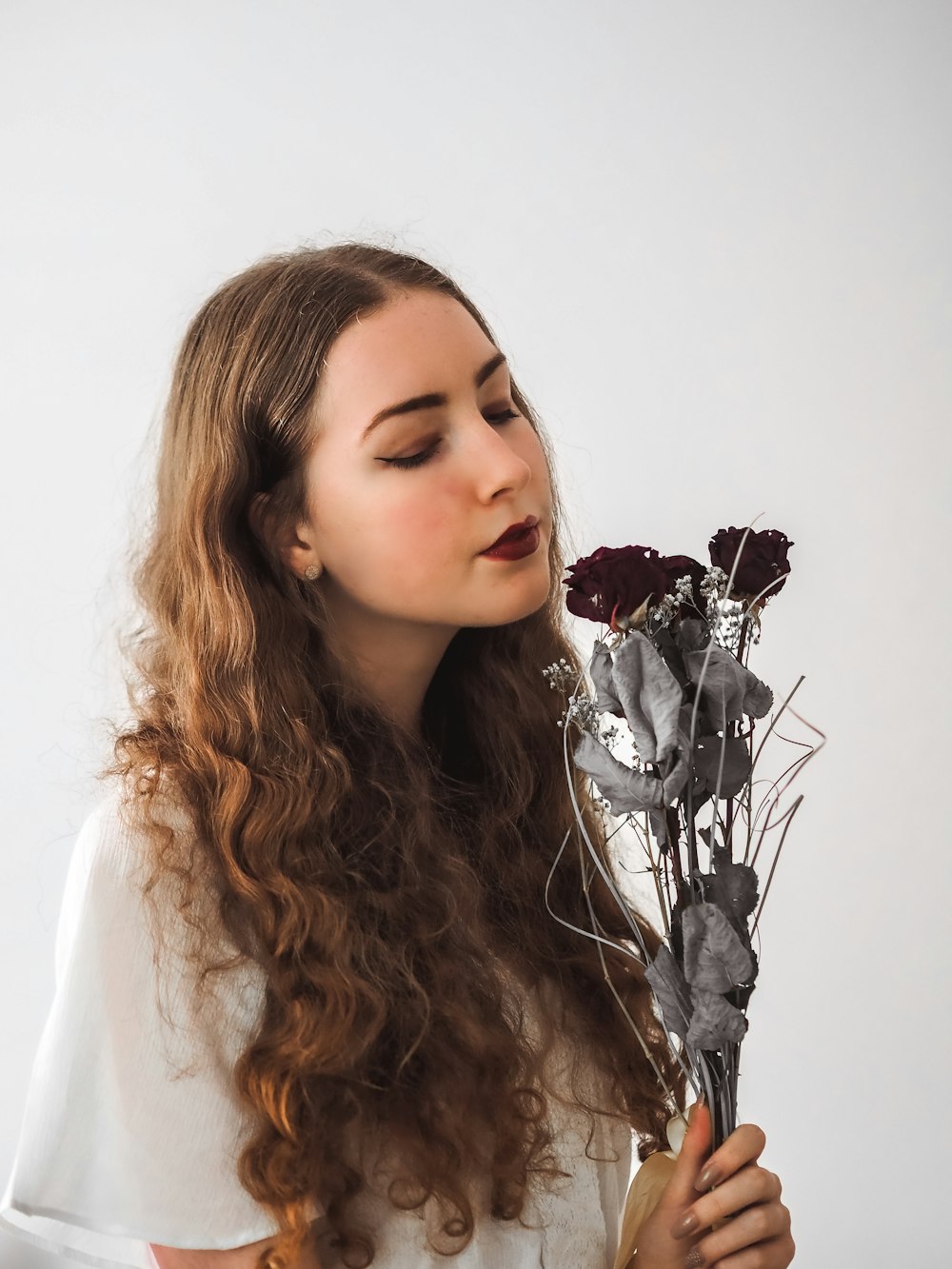 Mujer con camisa blanca con diadema de flores plateadas