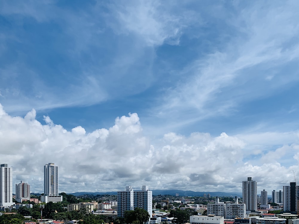 city buildings under blue sky and white clouds during daytime