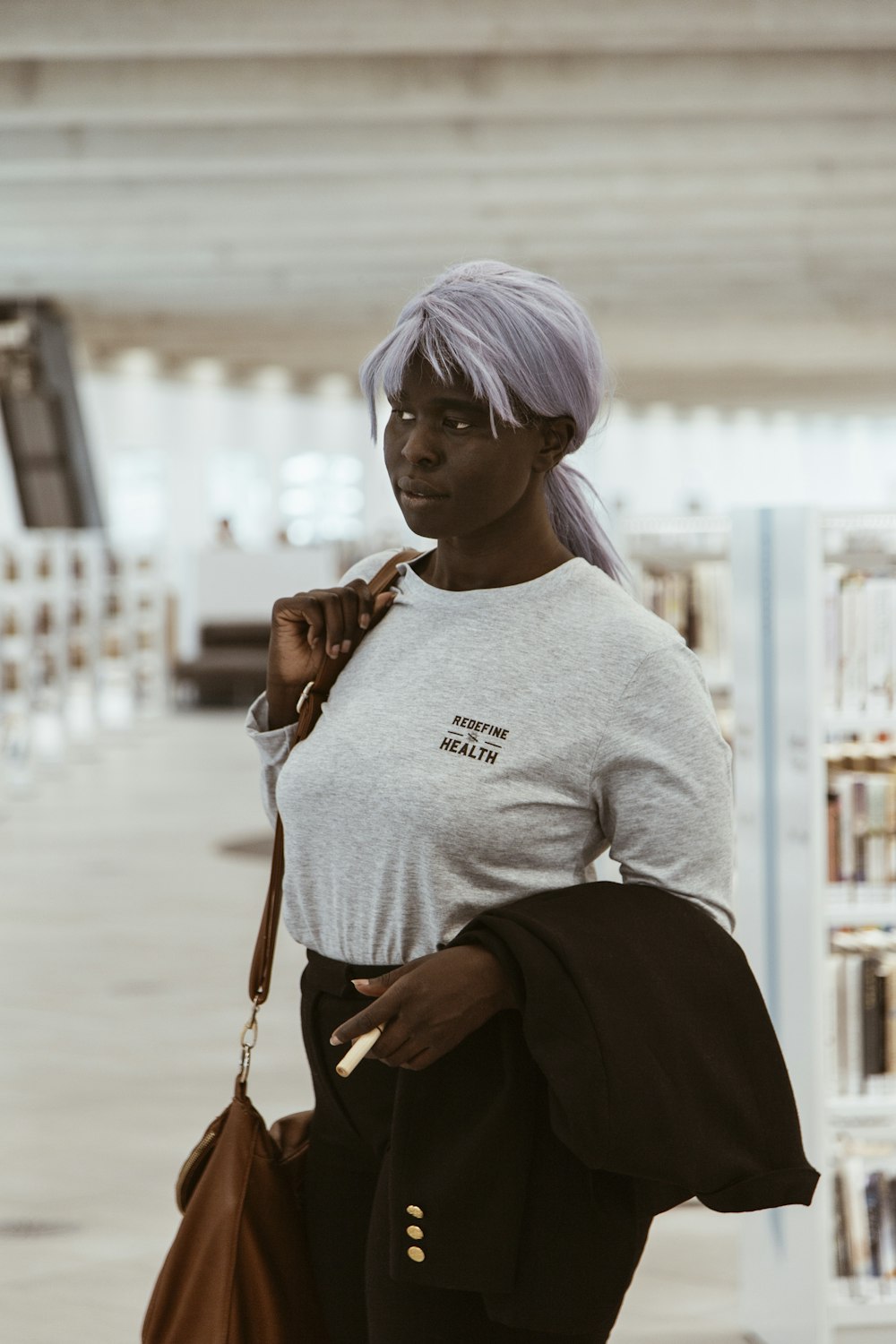 woman in gray sweater and black pants with purple hair