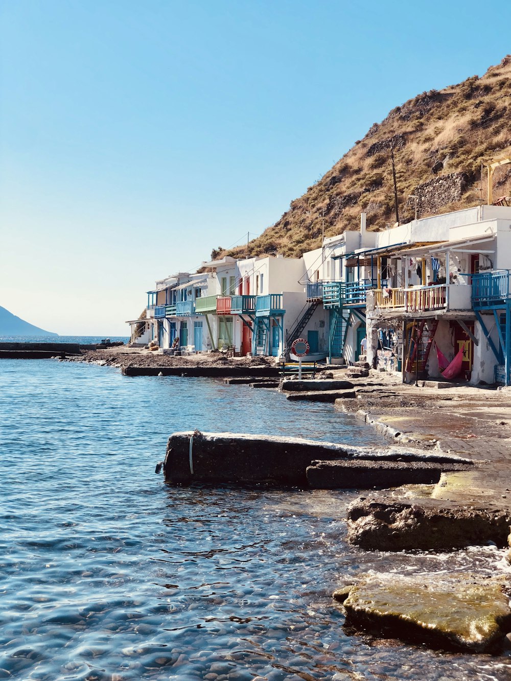 boats on sea near houses during daytime