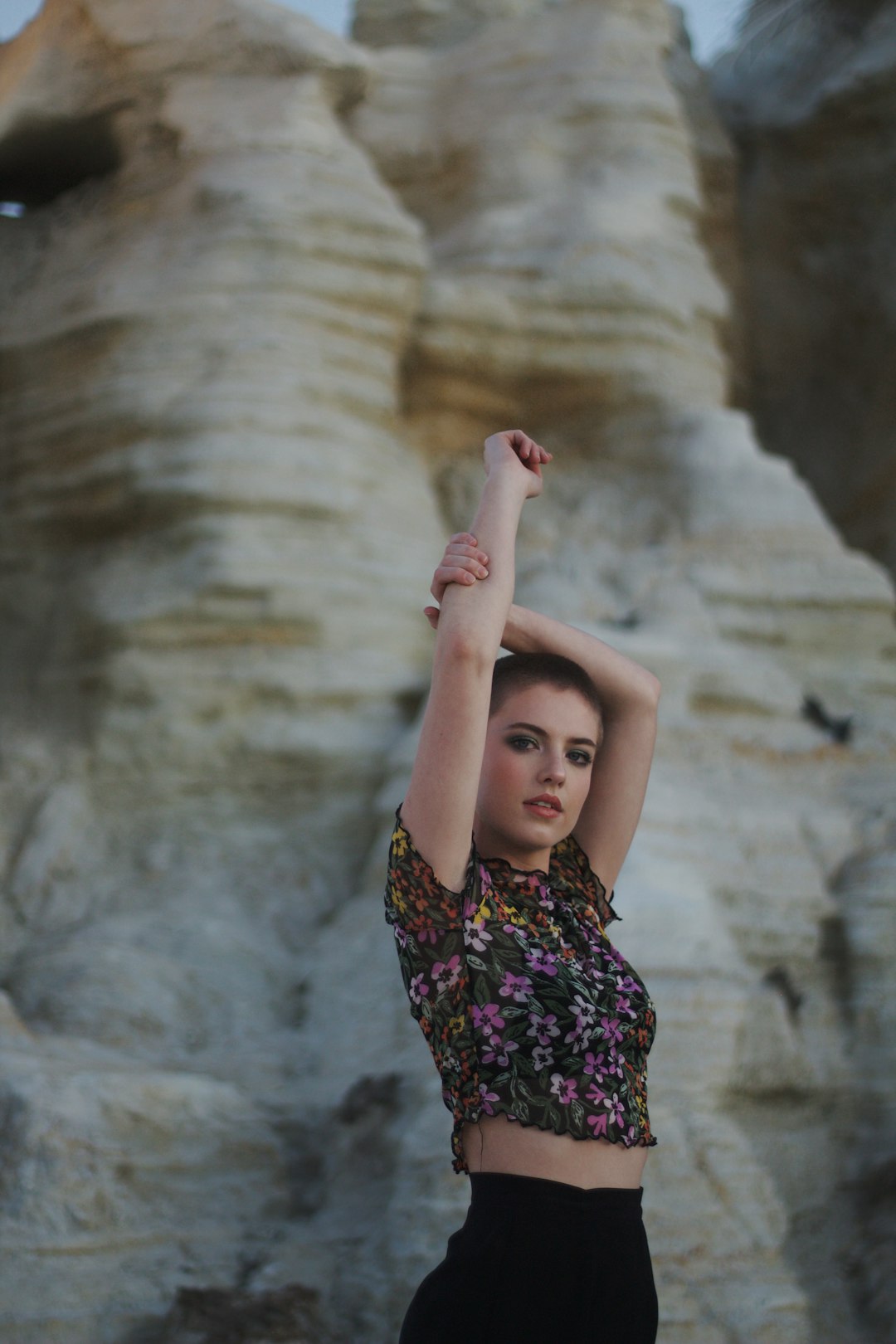 woman in black and pink floral dress raising her right hand