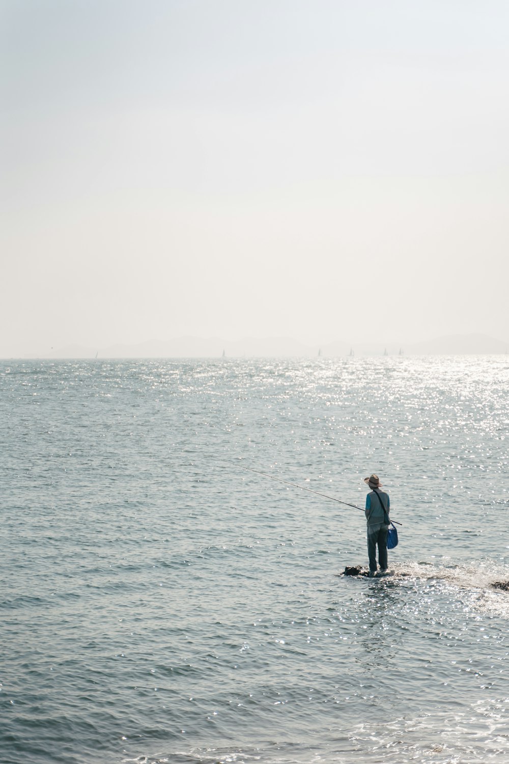 man in black jacket and black pants standing on sea shore during daytime