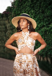 woman in brown and white floral spaghetti strap dress wearing brown sun hat
